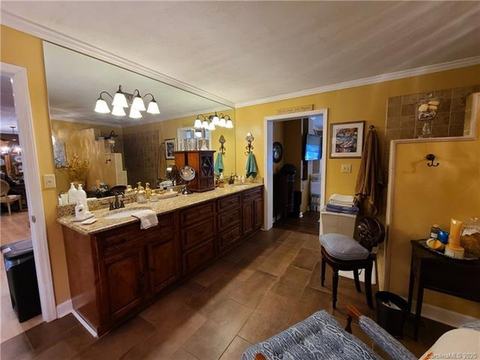 Bathroom with a long double vanity, wide mirror and wood cabinets.