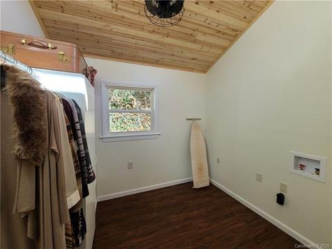 Closet space with a hanging rack and wall laundry hookups.